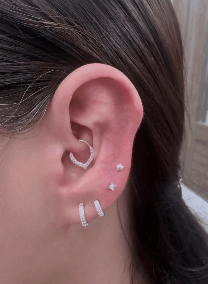 Perforación de oreja realizada con aros plateados